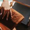 Mendil · étoffe de soin LUMEA — coton bouclé terracotta, posé sur le bois
