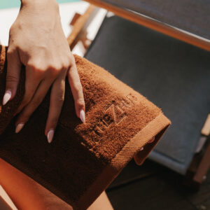 Mendil · étoffe de soin LUMEA — coton bouclé terracotta, posé sur le bois